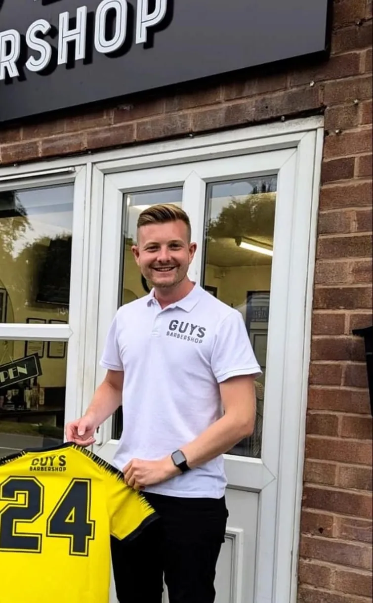 Guy outside the shop holding the sponsored Bromsgrove Rovers AFC shirt